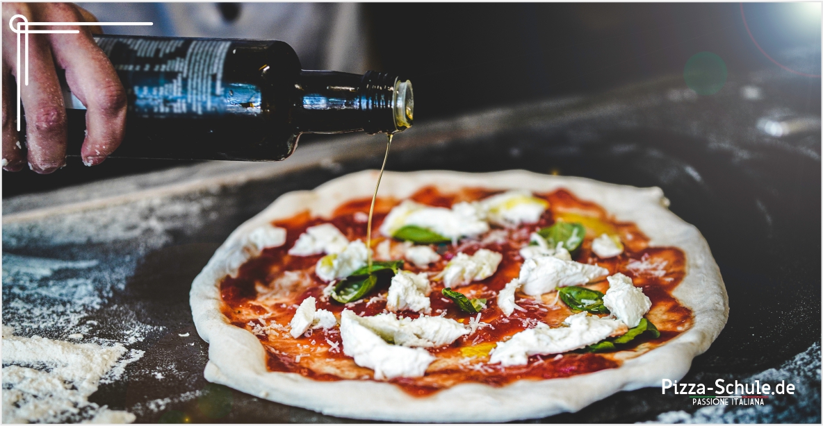 Pizzabäcker bereitet neapolitanische Pizza mit Olivenöl zu Pizzabäcker bereitet neapolitanische Pizza mit Olivenöl zu